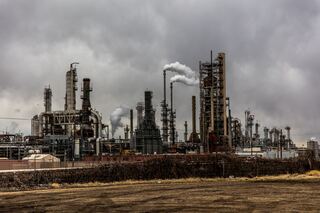 Landscape of large factory with cloudy skies.